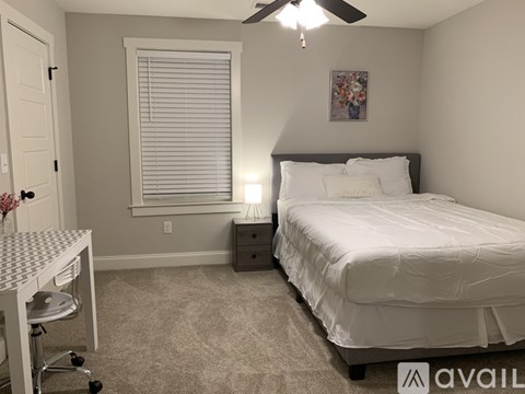 A bedroom with a bed, desk, and chair.
