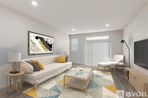 A modern living room with a white sofa, a coffee table, and a painting on the wall.