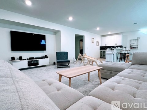 A modern living room with a grey sofa and a wooden coffee table.