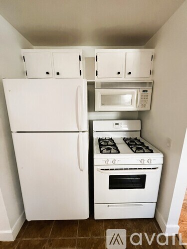 A white refrigerator and oven in a kitchen.
