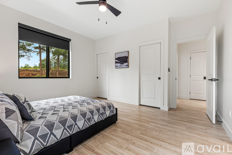 A bedroom with a large bed and a ceiling fan.