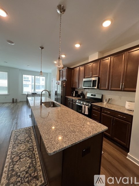 A kitchen with brown cabinets and granite countertops.