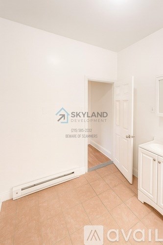 A room with a wall that has a logo for Skyland Development and a phone number on it.