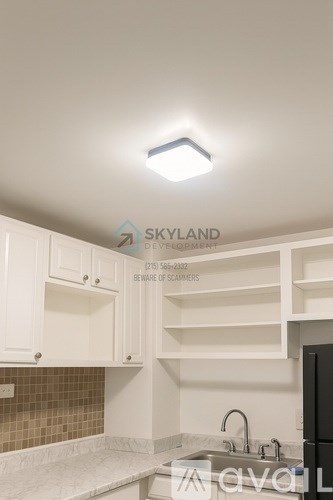 A kitchen with white cabinets and a tile backsplash.