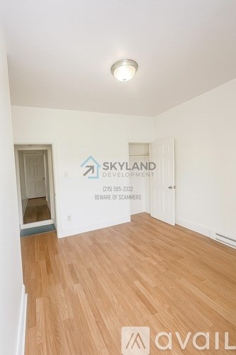 A room with wooden flooring and a sign for Skyland Development.