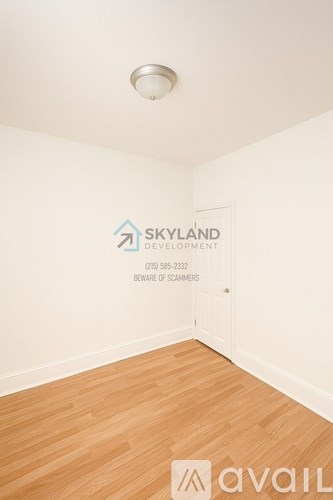 A room with a logo of Skyland Development and a phone number on the wall.