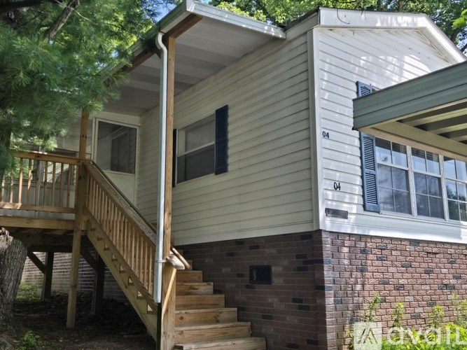 A house with a wooden staircase leading to a balcony.