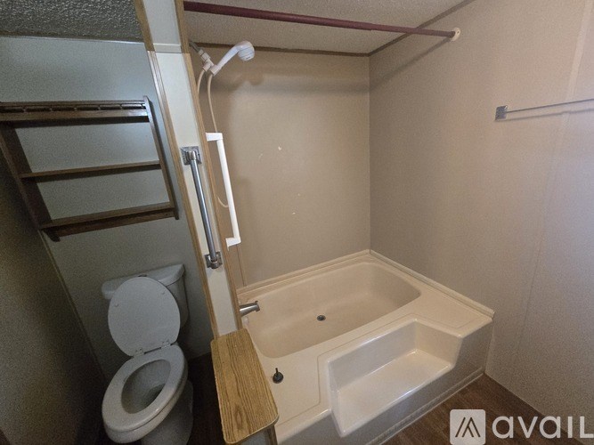 A small bathroom with a toilet, a bathtub, and a shower.