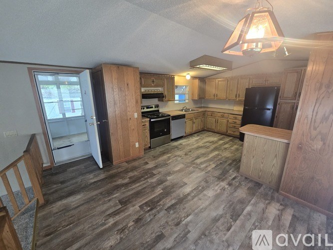 A kitchen with wooden cabinets and a black refrigerator.
