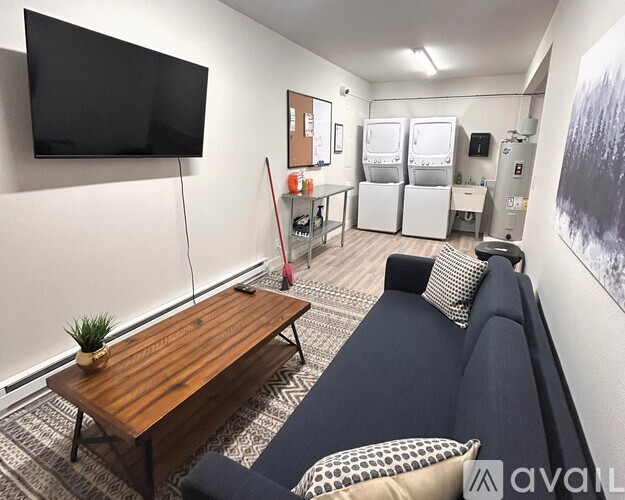 A living room with a couch, a coffee table, and a television.