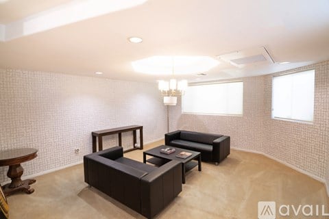 A living room with a black couch and a wooden table.