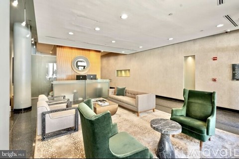 A living room with a green chair and a white sofa.