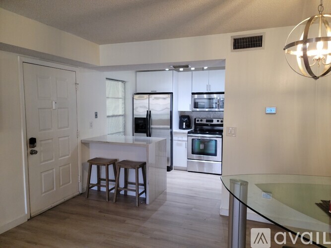 A kitchen with white cabinets and a white door.