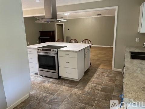 A kitchen with a tile floor and a stove top oven.