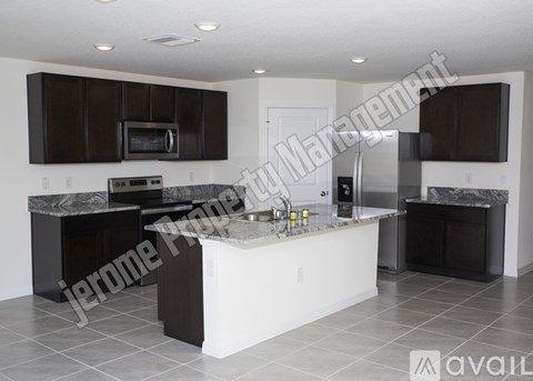 A modern kitchen with dark brown cabinets and a white island.