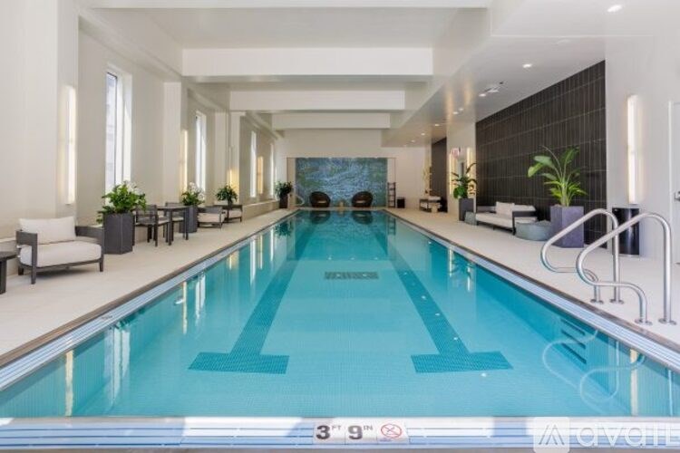 A large indoor swimming pool with a blue bottom and a white top.