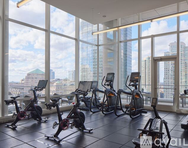 A gym with exercise bikes and a view of the city.