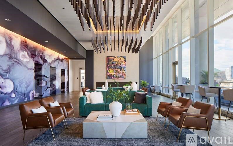 A modern living room with a large painting and a long marble-like wall.