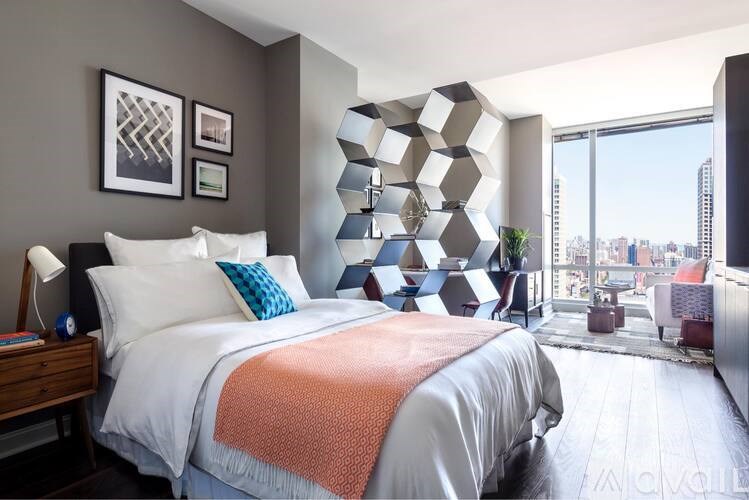 A bedroom with a large bed and a view of the city.