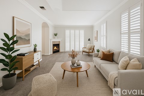 A living room with a fireplace and a painting on the wall.