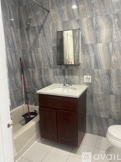 A bathroom with a marble wall and a white sink.