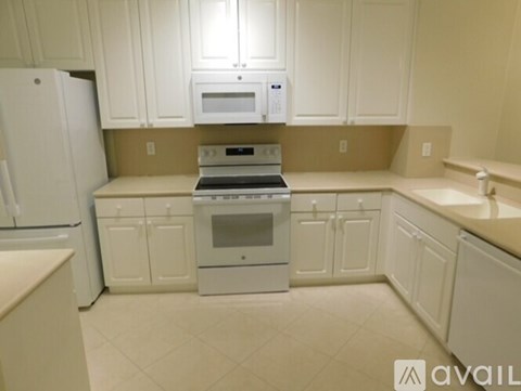 A kitchen with white cabinets and appliances.