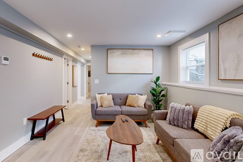A living room with a grey couch, a brown coffee table, and a large painting on the wall.