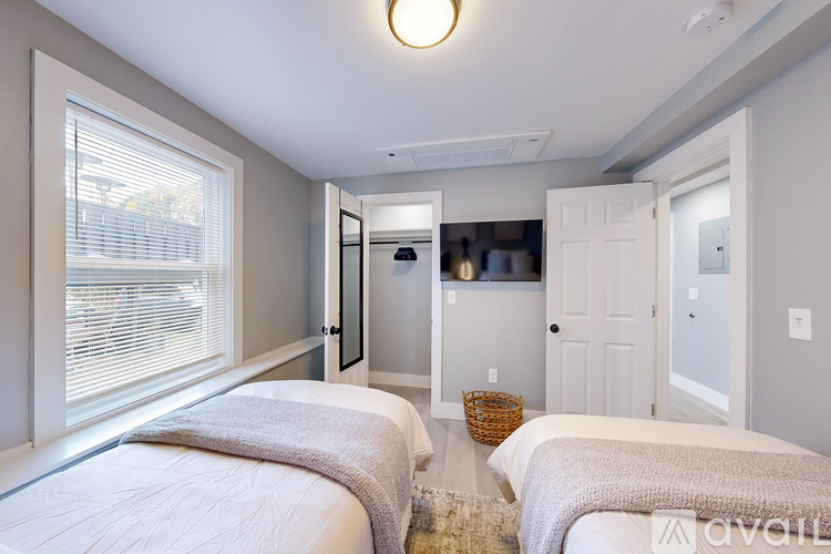 A bedroom with two beds and a basket on the floor.