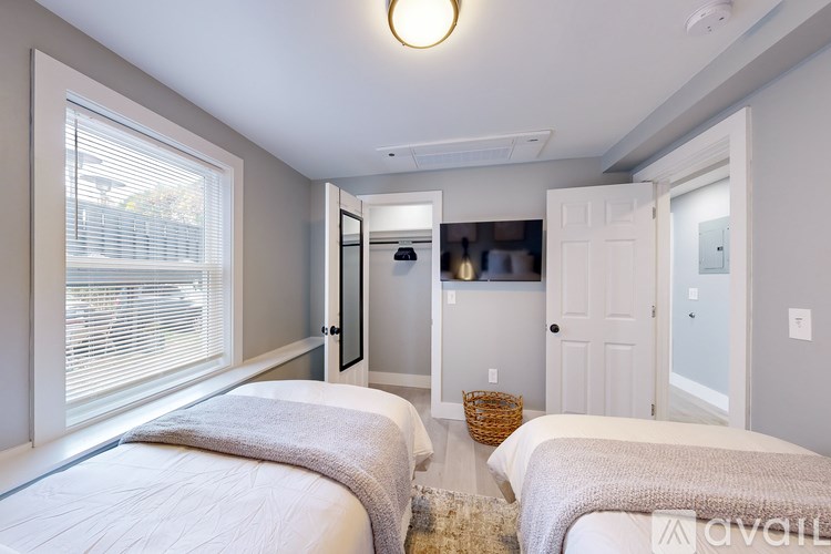A bedroom with two beds and a basket on the floor.