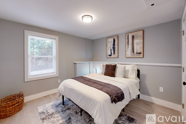 A bedroom with a large bed and two pictures on the wall.