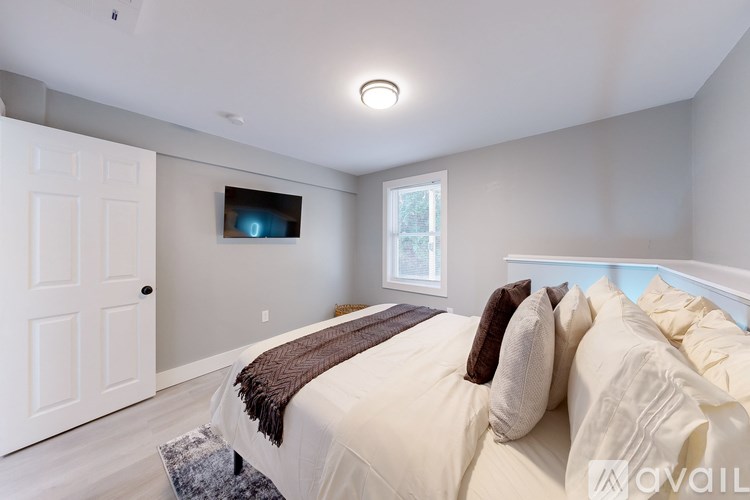 A bedroom with a large bed and a flat screen TV mounted on the wall.