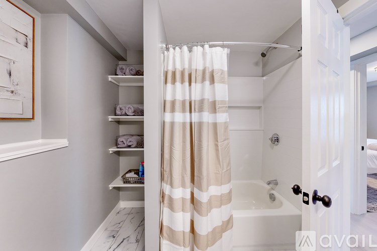 A bathroom with a shower curtain and a white tub.