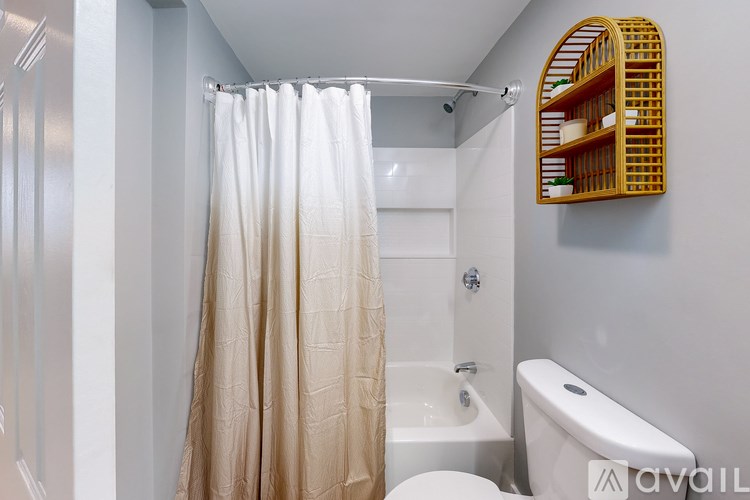 A bathroom with a white toilet, a white sink, and a white shower curtain.