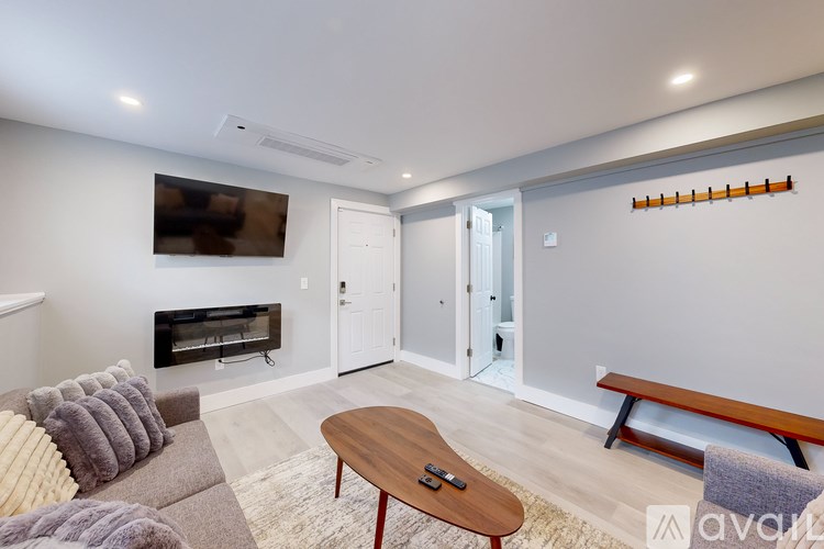 A living room with a couch, a coffee table, and a television.