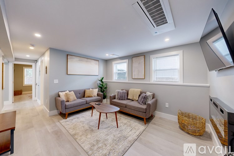 A living room with a grey couch and a brown coffee table.