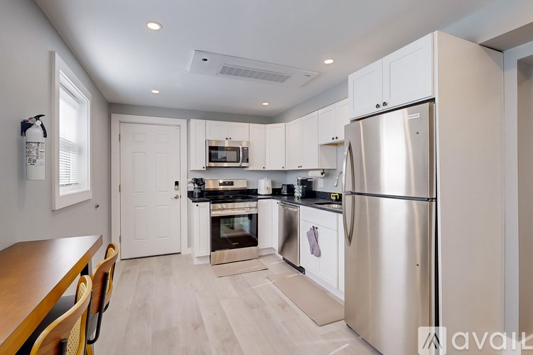 A kitchen with a refrigerator, oven, and microwave.