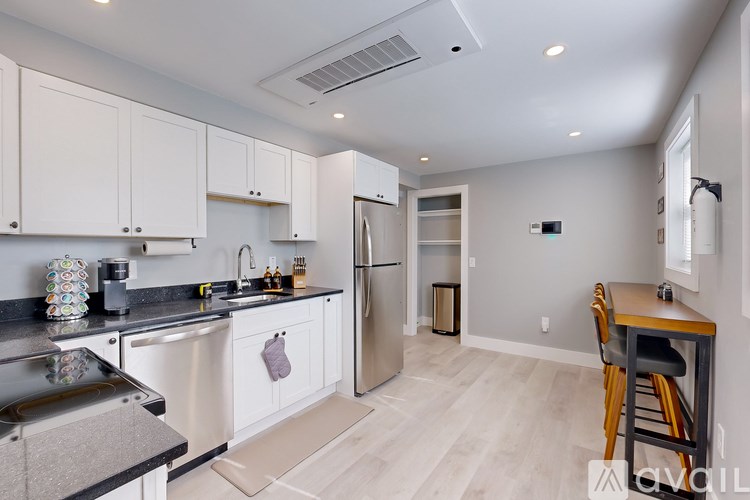 A kitchen with white cabinets and a black countertop.