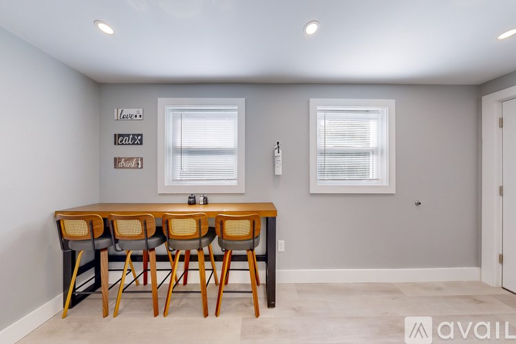 A dining room with a wooden table and chairs.