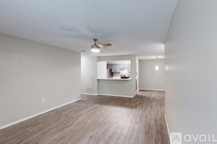 A room with a ceiling fan and wooden flooring.