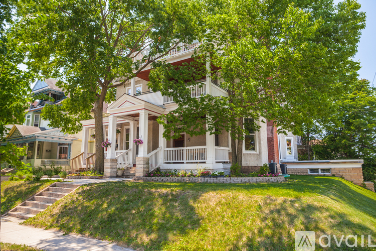 A house with a front porch and a tree in front of it.