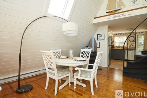 A dining room with a white table and chairs.