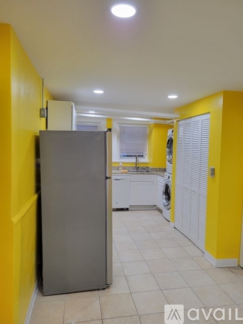 A kitchen with yellow walls and a grey fridge.