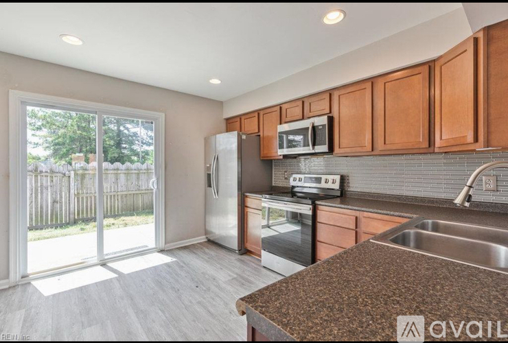 A kitchen with brown cabinets and a stainless steel refrigerator.
