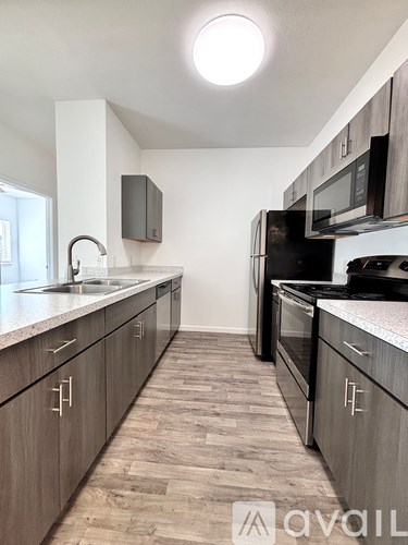A kitchen with wooden cabinets and a black refrigerator.