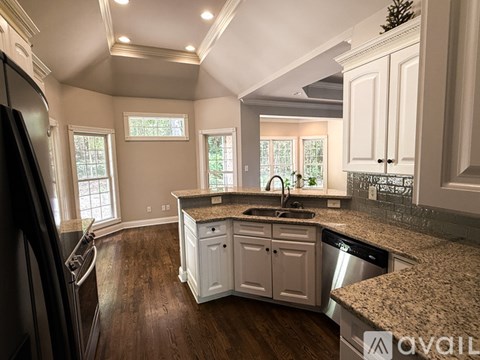 A kitchen with white cabinets and a granite countertop.