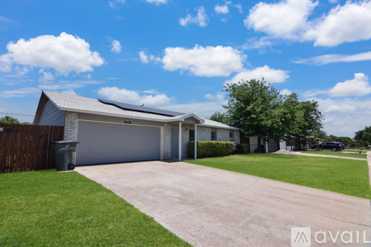 A house with a garage and a driveway in front of it.