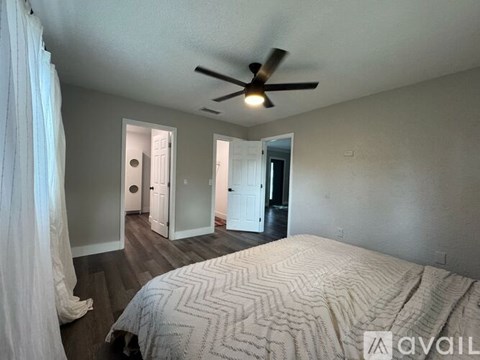 A bedroom with a large bed and a ceiling fan.