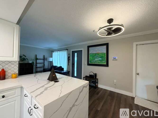 A kitchen with white cabinets and a marble countertop.