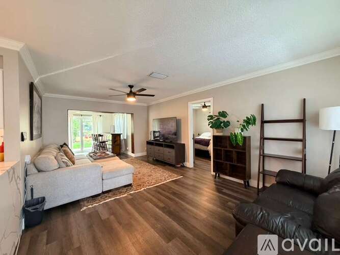 A living room with a grey sofa and a wooden floor.