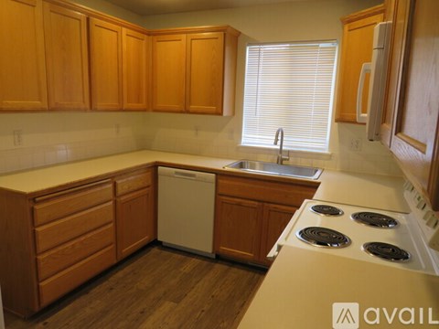 A kitchen with wooden cabinets and a white dishwasher.
